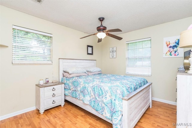 1505 Terrace Ct, Opelika, AL 36081 - bedroom with light wood finished floors, multiple windows, baseboards, and a textured ceiling