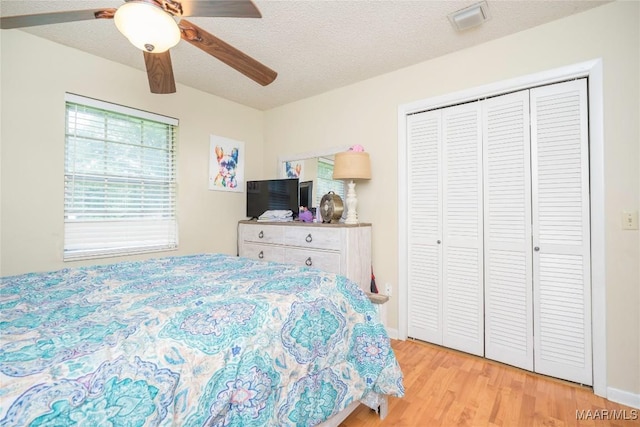 1505 Terrace Ct, Opelika, AL 36081 - bedroom featuring light wood-style floors, a textured ceiling, a closet, and ceiling fan