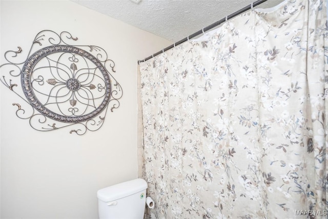 1505 Terrace Ct, Opelika, AL 36081 - bathroom featuring a textured ceiling, toilet, and a shower with shower curtain