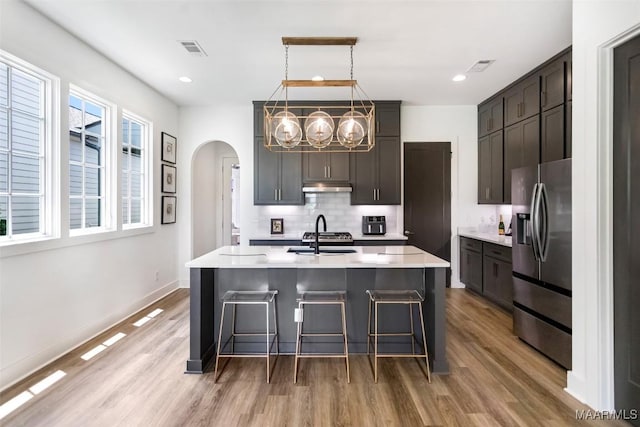 4808 Clerkenwell St, Montgomery, AL 36116 - kitchen with stainless steel refrigerator with ice dispenser, a sink, under cabinet range hood, light wood-style flooring, and recessed lighting