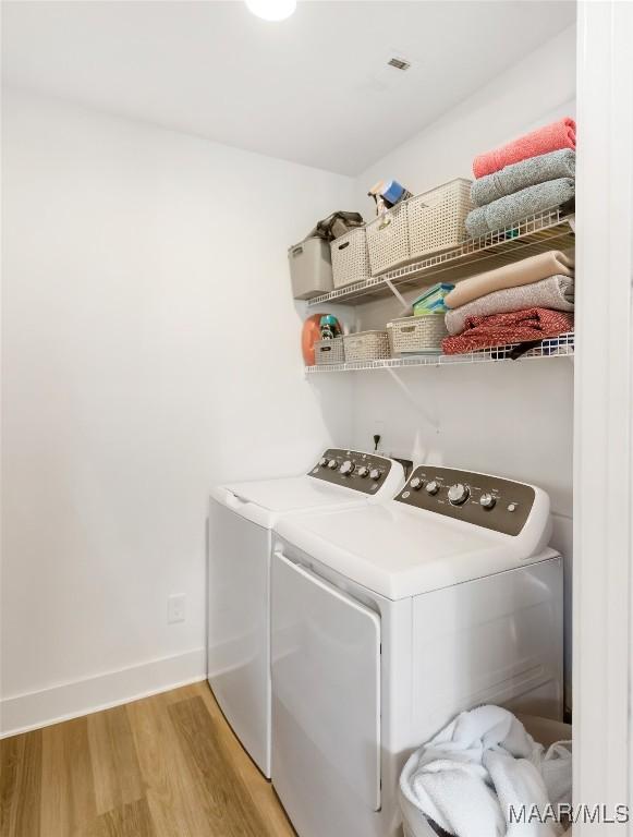 4808 Clerkenwell St, Montgomery, AL 36116 - laundry area with washing machine and clothes dryer, light wood-style floors, and baseboards