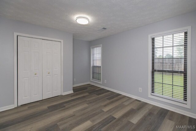 355 Hambleton Ct, Montgomery, AL 36117 - unfurnished bedroom with dark wood-type flooring, baseboards, a closet, and a textured ceiling