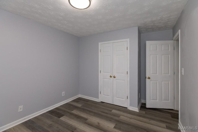 355 Hambleton Ct, Montgomery, AL 36117 - unfurnished bedroom featuring dark wood-type flooring, a textured ceiling, a closet, and baseboards