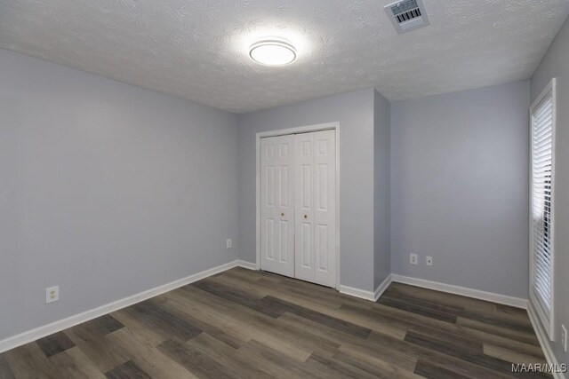 355 Hambleton Ct, Montgomery, AL 36117 - unfurnished bedroom featuring dark wood-style floors, baseboards, a closet, and a textured ceiling