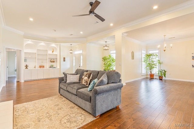 8115 Bridgewater Trce, Montgomery, AL 36117 - living room featuring wood finished floors, ceiling fan, ornamental molding, baseboards, and a chandelier