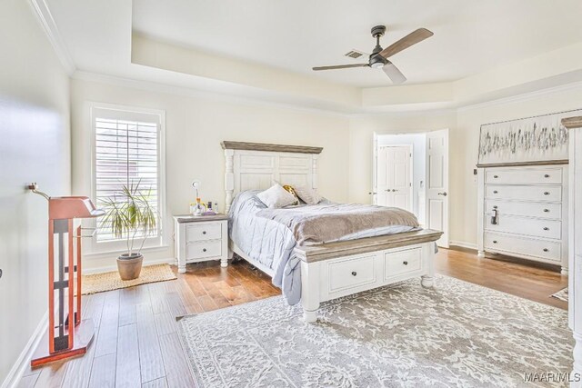 8115 Bridgewater Trce, Montgomery, AL 36117 - bedroom featuring a tray ceiling, wood finished floors, ornamental molding, and baseboards