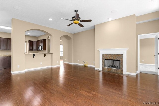 9000 Finsburry Ct, Montgomery, AL 36117 - unfurnished living room featuring a ceiling fan, recessed lighting, wood finished floors, a tiled fireplace, and baseboards