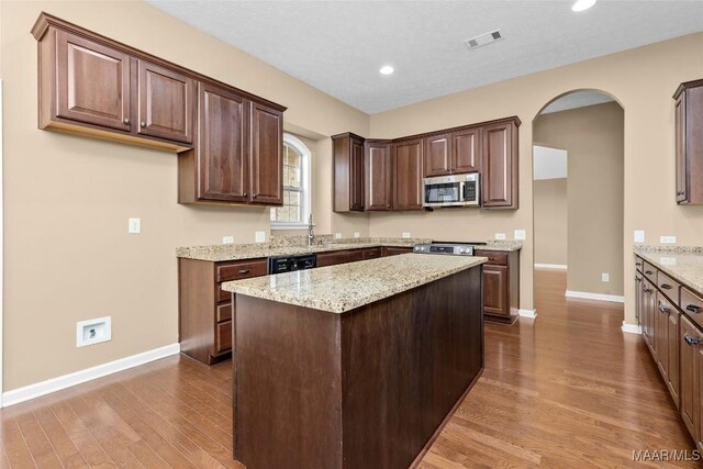 9000 Finsburry Ct, Montgomery, AL 36117 - kitchen with appliances with stainless steel finishes, baseboards, dark wood-type flooring, arched walkways, and a center island