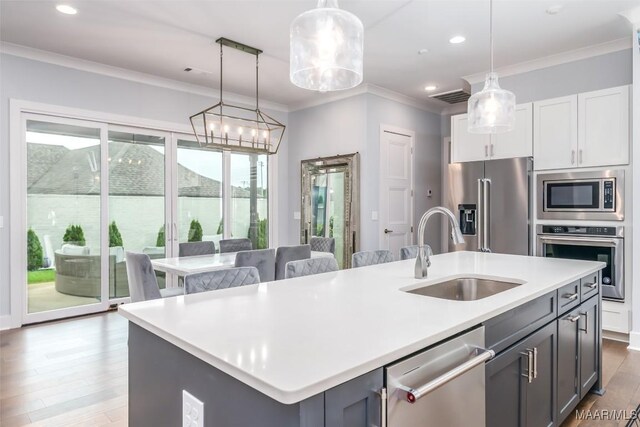 7175 Fain Park Loop, Montgomery, AL 36117 - kitchen with stainless steel appliances, a sink, a kitchen island with sink, ornamental molding, and wood finished floors