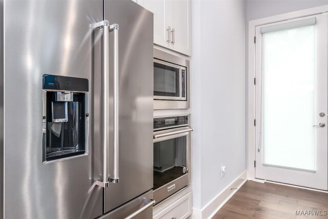 7175 Fain Park Loop, Montgomery, AL 36117 - kitchen with stainless steel appliances, white cabinetry, wood finished floors, and baseboards