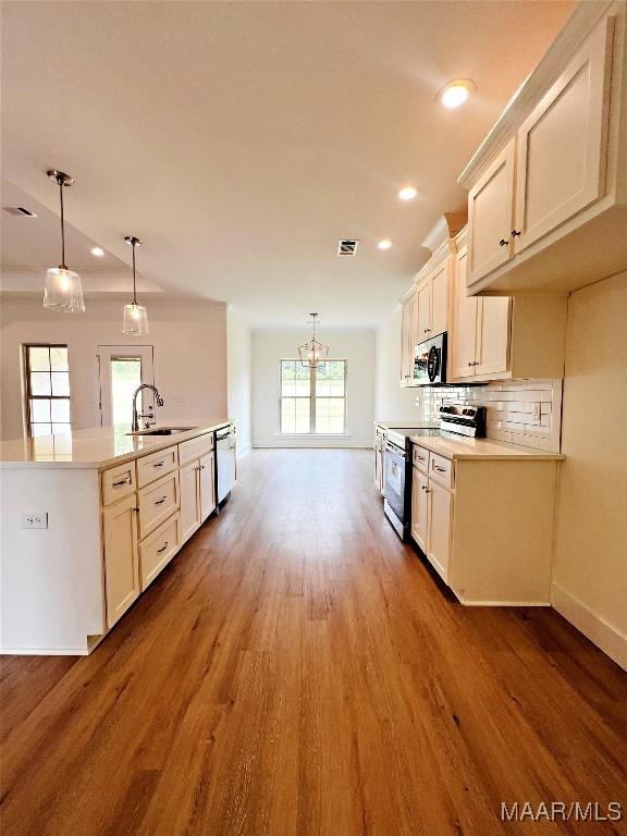 40 Serene Ln, Wetumpka, AL 36093 - kitchen with stainless steel appliances, a chandelier, wood finished floors, recessed lighting, and tasteful backsplash