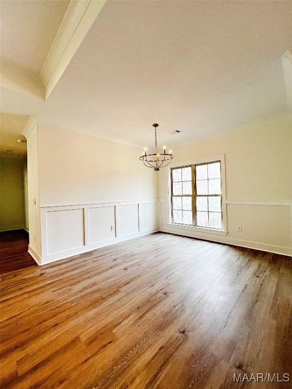 60 Serene Ln, Wetumpka, AL 36093 - unfurnished room featuring wood finished floors, a chandelier, a wainscoted wall, and a decorative wall