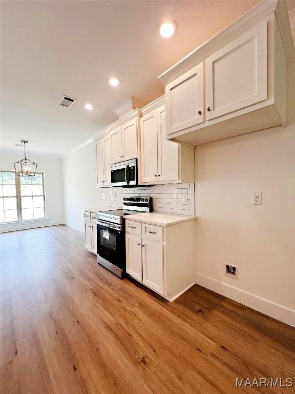 60 Serene Ln, Wetumpka, AL 36093 - kitchen featuring appliances with stainless steel finishes, a chandelier, tasteful backsplash, light wood-type flooring, and recessed lighting
