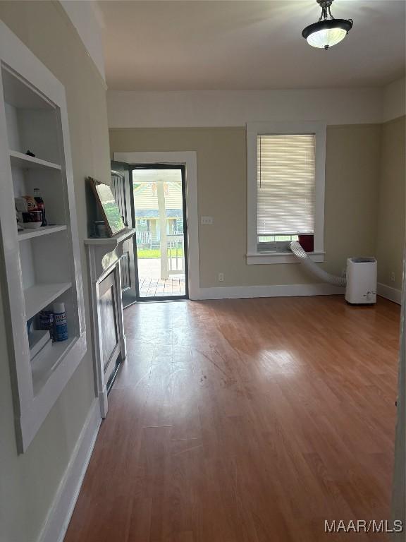 301 Riverside Ave, Tallassee, AL 36078 - unfurnished living room featuring baseboards, wood finished floors, and built in features