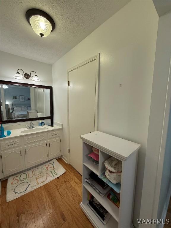 530 Palmquist Dr, Selma, AL 36701 - ensuite bathroom featuring a textured ceiling, vanity, and wood finished floors
