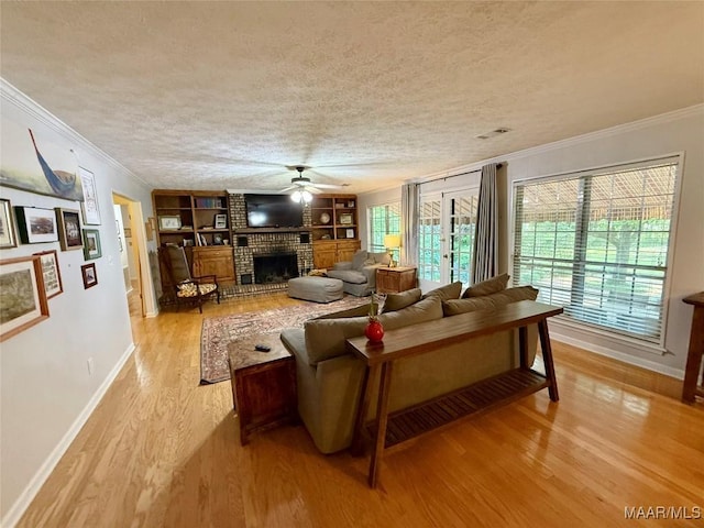 530 Palmquist Dr, Selma, AL 36701 - living room featuring crown molding, a ceiling fan, light wood-type flooring, a fireplace, and a textured ceiling