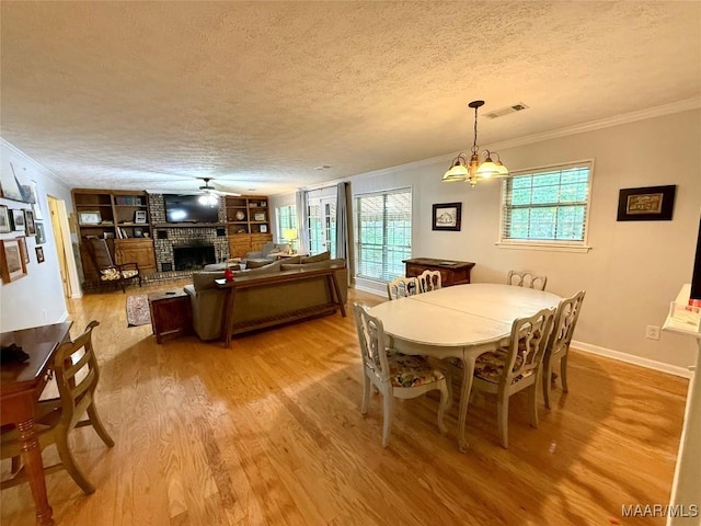530 Palmquist Dr, Selma, AL 36701 - dining room featuring a textured ceiling, light wood-style floors, ornamental molding, a fireplace, and built in features