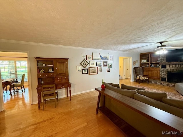 530 Palmquist Dr, Selma, AL 36701 - living room featuring a ceiling fan, light wood-style flooring, a textured ceiling, a fireplace, and ornamental molding