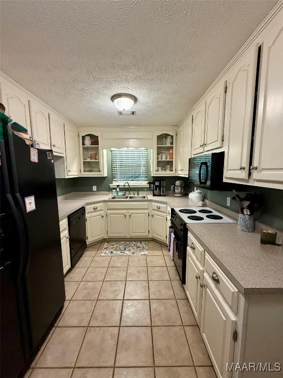530 Palmquist Dr, Selma, AL 36701 - kitchen featuring black appliances, glass insert cabinets, a textured ceiling, white cabinets, and light tile patterned floors