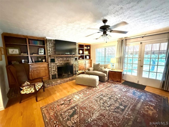 530 Palmquist Dr, Selma, AL 36701 - living area featuring a textured ceiling, ceiling fan, wood finished floors, and a fireplace