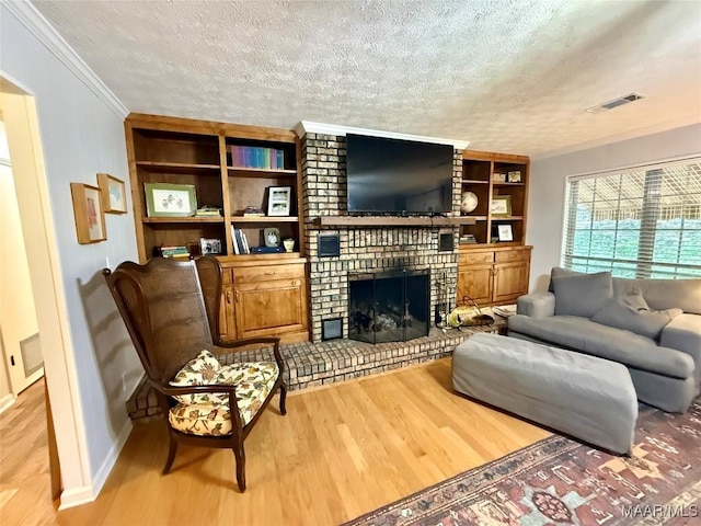 530 Palmquist Dr, Selma, AL 36701 - living area featuring wood finished floors, crown molding, a brick fireplace, a textured ceiling, and built in features