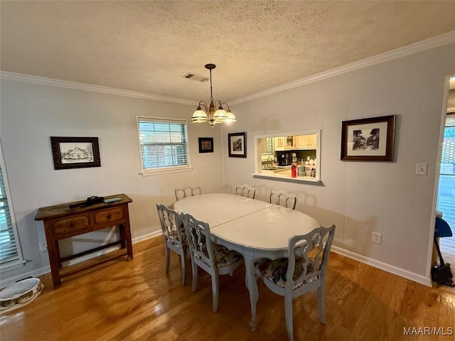 530 Palmquist Dr, Selma, AL 36701 - dining space featuring a chandelier, wood finished floors, ornamental molding, and a textured ceiling