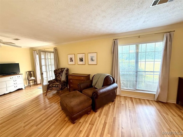 530 Palmquist Dr, Selma, AL 36701 - living room featuring a textured ceiling, light wood-type flooring, healthy amount of natural light, ornamental molding, and a ceiling fan