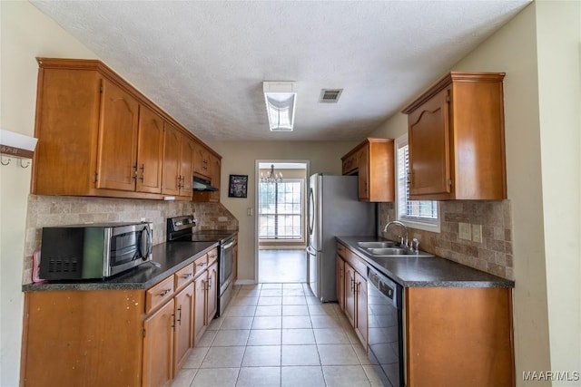 242 Preakness Path, Montgomery, AL 36117 - kitchen with stainless steel appliances, a sink, dark countertops, under cabinet range hood, and decorative backsplash