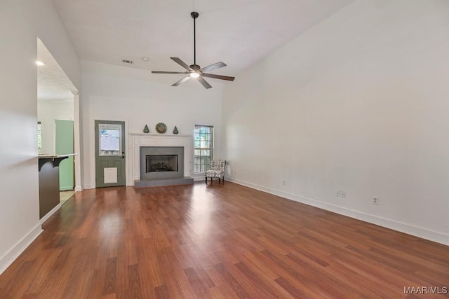 505 Mountain Ridge Rd, Millbrook, AL 36054 - unfurnished living room featuring ceiling fan, wood finished floors, baseboards, a fireplace with raised hearth, and high vaulted ceiling