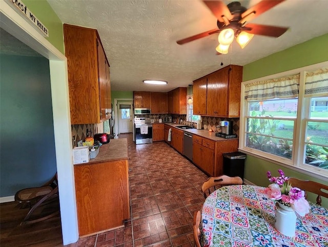 445 W Hickory Grove Rd, Lapine, AL 36046 - kitchen featuring stainless steel appliances, a sink, brown cabinetry, ceiling fan, and light countertops