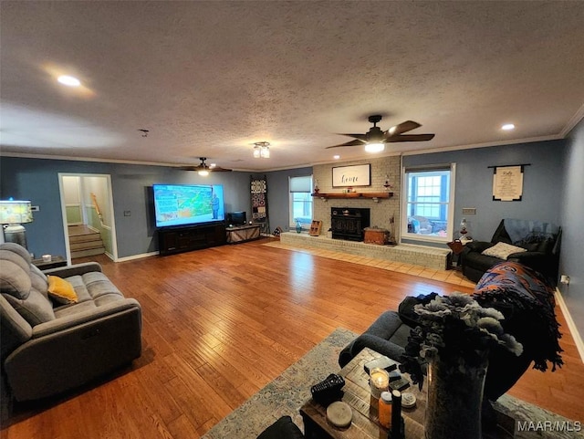 445 W Hickory Grove Rd, Lapine, AL 36046 - living room featuring a ceiling fan, crown molding, a brick fireplace, stairway, and wood finished floors
