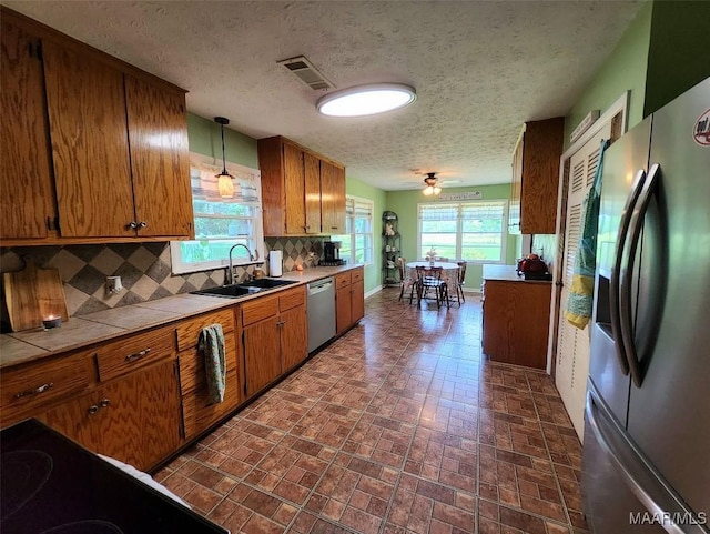 445 W Hickory Grove Rd, Lapine, AL 36046 - kitchen featuring appliances with stainless steel finishes, a sink, tile countertops, brown cabinetry, and brick patterned floors