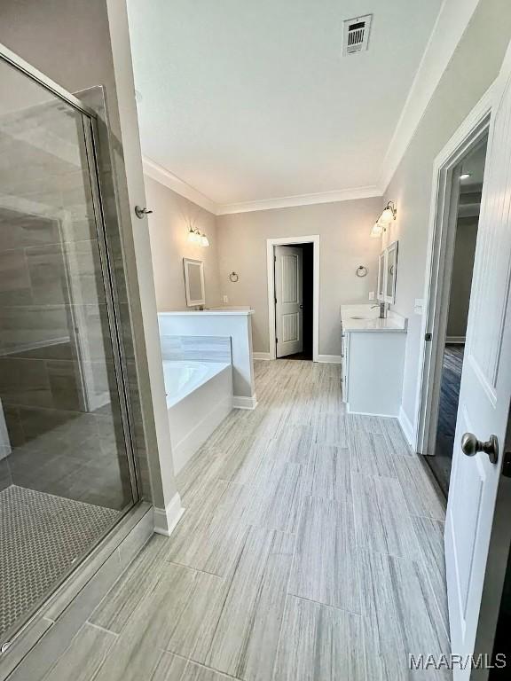 2348 Burt Mill Rd, Tallassee, AL 36078 - full bath with vanity, a bath, a shower stall, ornamental molding, and baseboards