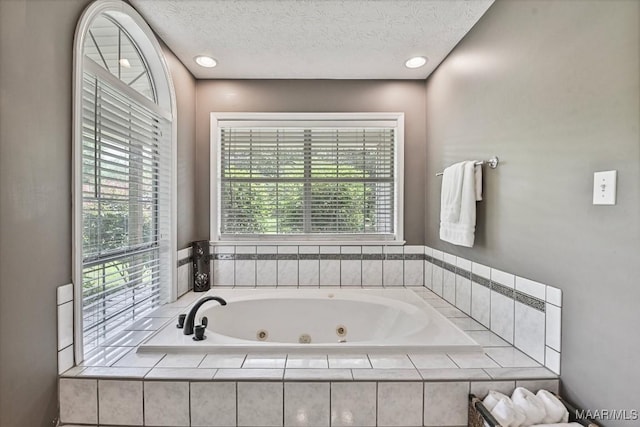 594 Lewis Rd, Deatsville, AL 36022 - bathroom featuring a jetted tub, healthy amount of natural light, and a textured ceiling