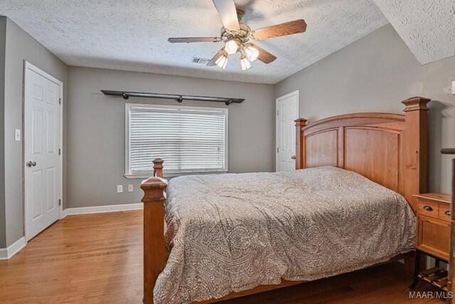 594 Lewis Rd, Deatsville, AL 36022 - bedroom featuring light wood-type flooring, a textured ceiling, baseboards, and a ceiling fan