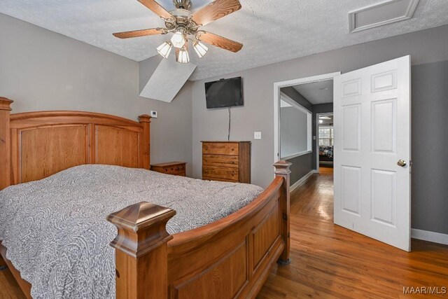 594 Lewis Rd, Deatsville, AL 36022 - bedroom with wood finished floors, baseboards, a textured ceiling, attic access, and ceiling fan