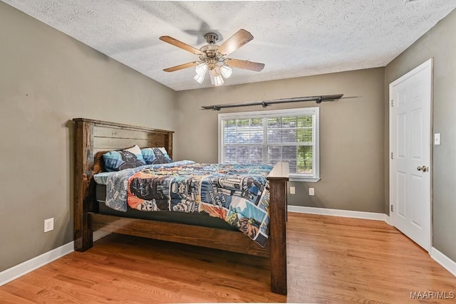 594 Lewis Rd, Deatsville, AL 36022 - bedroom featuring wood finished floors, a textured ceiling, baseboards, and ceiling fan