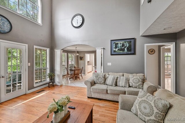 594 Lewis Rd, Deatsville, AL 36022 - living room featuring decorative columns, a towering ceiling, arched walkways, and plenty of natural light
