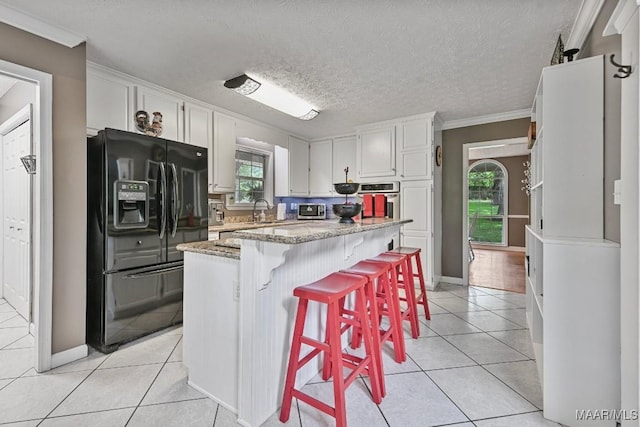 594 Lewis Rd, Deatsville, AL 36022 - kitchen with black refrigerator with ice dispenser, a sink, light tile patterned flooring, stainless steel oven, and crown molding