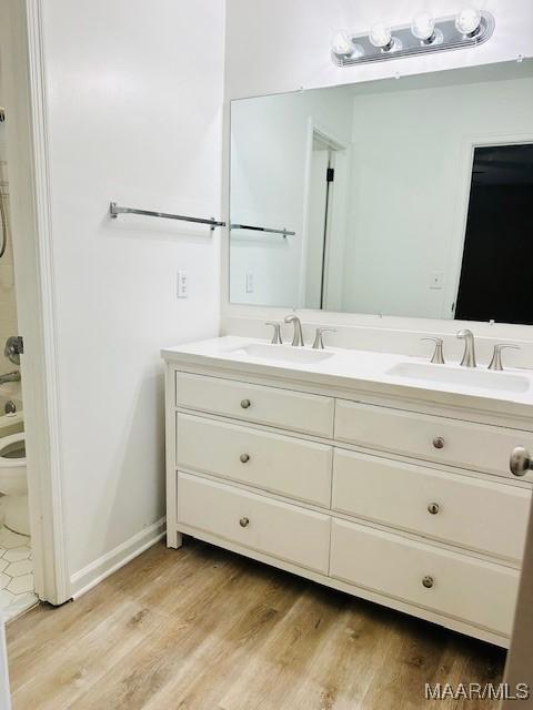 6118 Helga Pl, Montgomery, AL 36117 - bathroom featuring double vanity, toilet, and wood finished floors