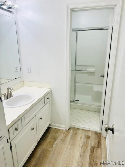6118 Helga Pl, Montgomery, AL 36117 - bathroom with vanity, a shower stall, and wood finished floors