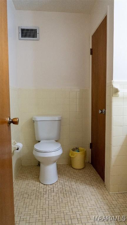 22 Daleview Cir, Sylacauga, AL 35150 - bathroom with wainscoting, tile walls, and toilet