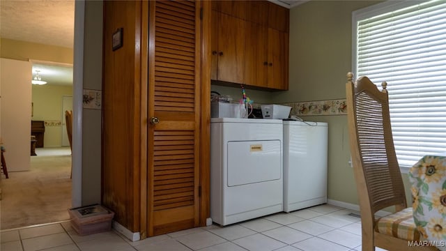 22 Daleview Cir, Sylacauga, AL 35150 - laundry area featuring separate washer and dryer, cabinet space, light tile patterned flooring, and baseboards