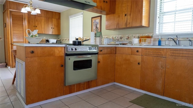 22 Daleview Cir, Sylacauga, AL 35150 - kitchen featuring stove, a chandelier, brown cabinets, a sink, and light tile patterned floors