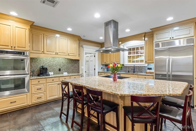 161 Watson Cir, Montgomery, AL 36109 - kitchen featuring island range hood, appliances with stainless steel finishes, decorative backsplash, a kitchen breakfast bar, and light stone countertops