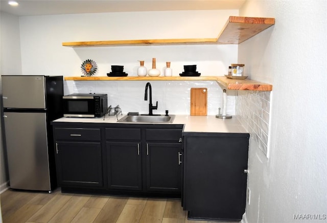 402 S Perry St, Montgomery, AL 36104 - kitchen with freestanding refrigerator, a sink, black microwave, and light wood finished floors