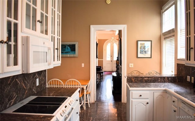 402 S Perry St, Montgomery, AL 36104 - kitchen featuring stove, decorative backsplash, white cabinets, and glass insert cabinets