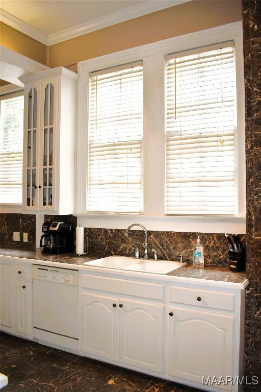 402 S Perry St, Montgomery, AL 36104 - kitchen with white dishwasher, ornamental molding, glass insert cabinets, a sink, and white cabinetry