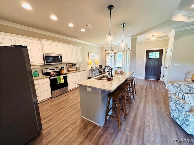 1670 Rifle Range Rd, Wetumpka, AL 36093 - kitchen featuring appliances with stainless steel finishes, a sink, ornamental molding, a breakfast bar, and wood finished floors