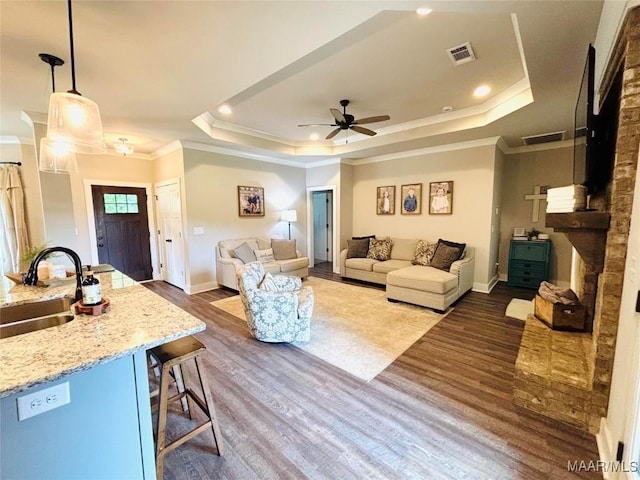 1670 Rifle Range Rd, Wetumpka, AL 36093 - living area featuring crown molding, a raised ceiling, dark wood-type flooring, baseboards, and a ceiling fan